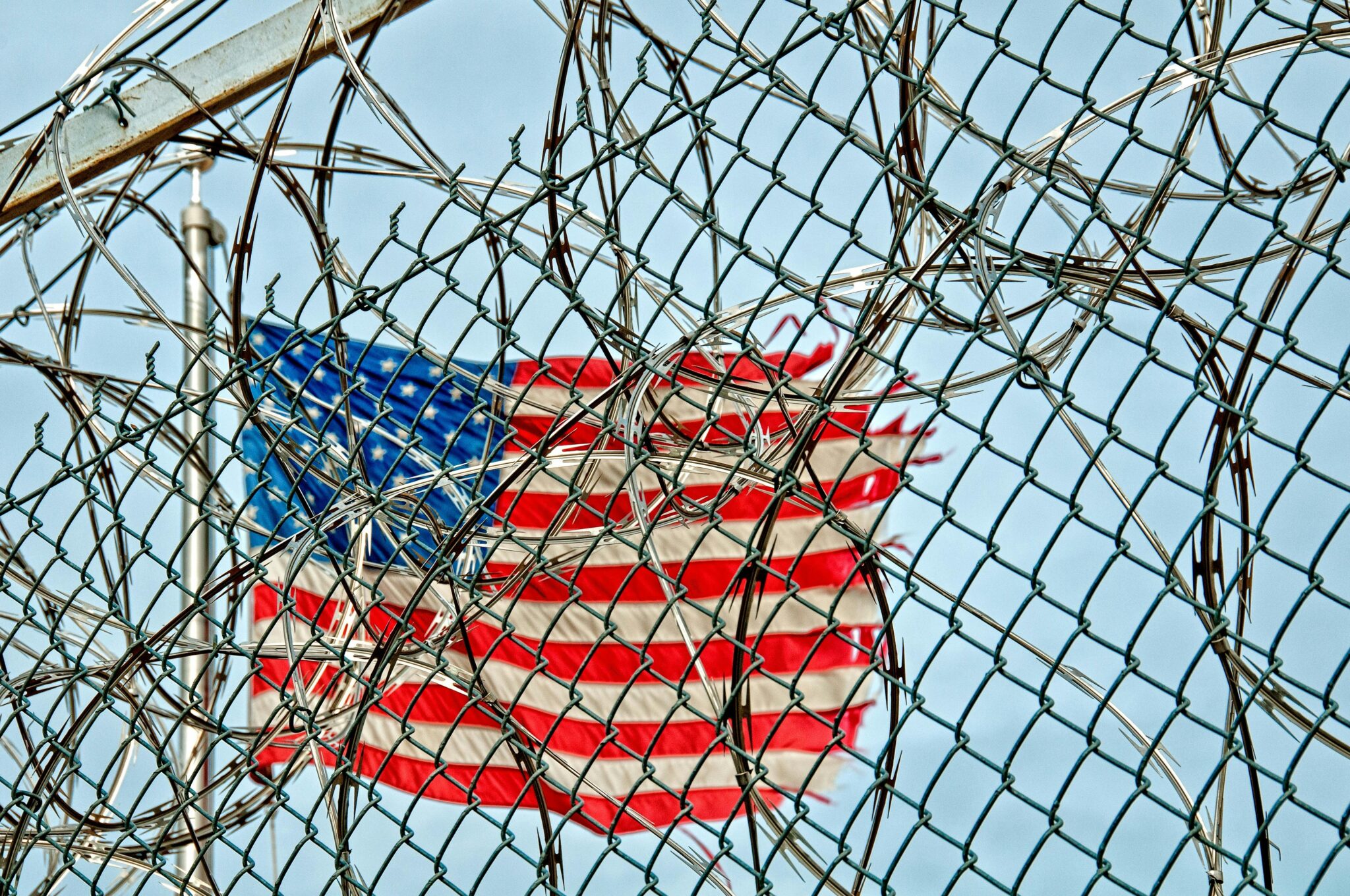 USA flag seen through barbed wire, symbolizing freedom and protection