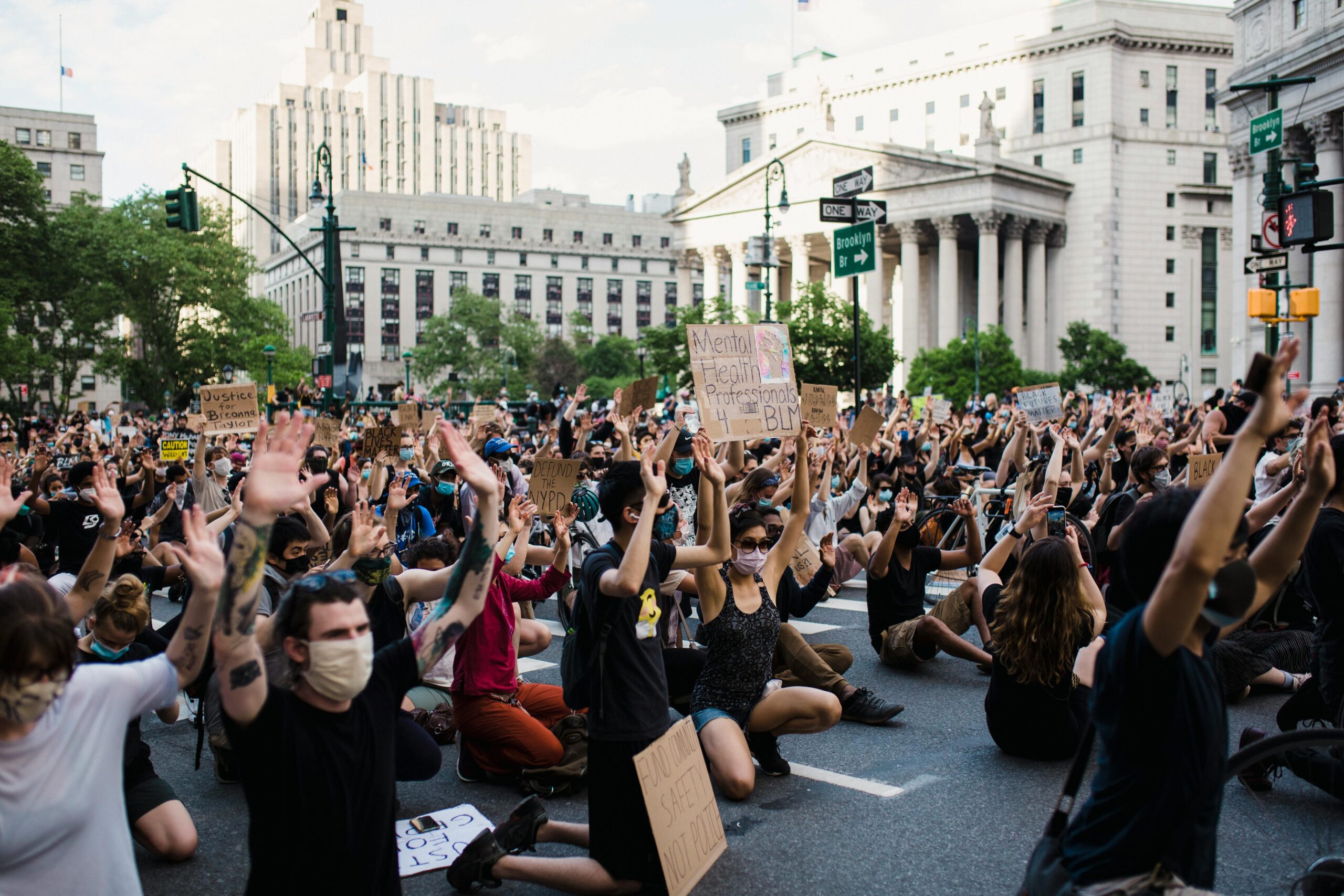 A large crowd demonstrates peacefully in the city, raising hands in support of justice and equality.